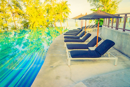 Umbrella pool chair - vintage filter and sunflare effectの写真素材