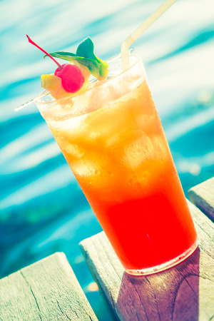 Fruit cocktail glass at pool - vintage filter effectの写真素材