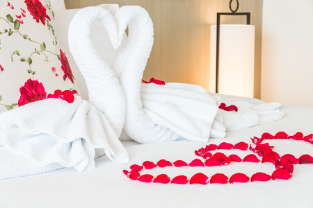 Towel swans and rose flower on bedroom for honeymoon couple - selective focus pointの写真素材