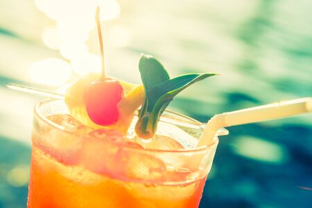 Fruit cocktail glass at pool - vintage filter effectの写真素材