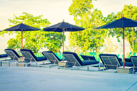Umbrella pool chair - vintage filter and sunflare effectの写真素材