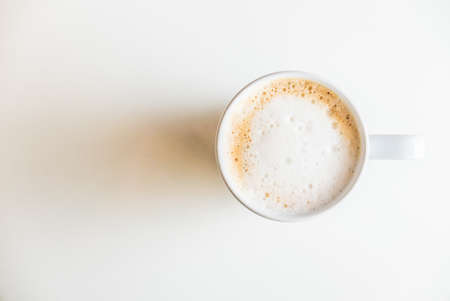 Top of view coffee cup on white table with hard light from side windowの写真素材
