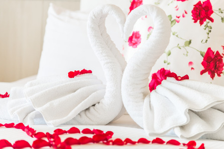 Towel swans and rose flower on bedroom for honeymoon couple - selective focus pointの写真素材