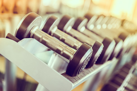 dumbbell in gym - vintage effect and sun flare filter effect