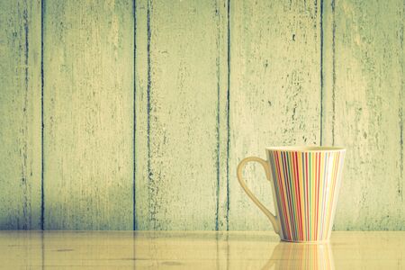 Colorful coffee cup on wood background - vintage filter effectの写真素材