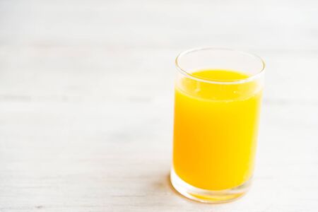 Orange juice glass with outdoor view backgroundの写真素材