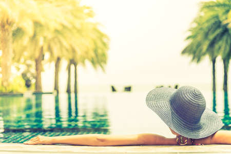 Young woman wearing straw hat in the pool - vintage filterの写真素材