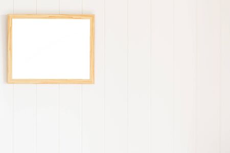 Blank photo frame on white wood wall backgroundの写真素材