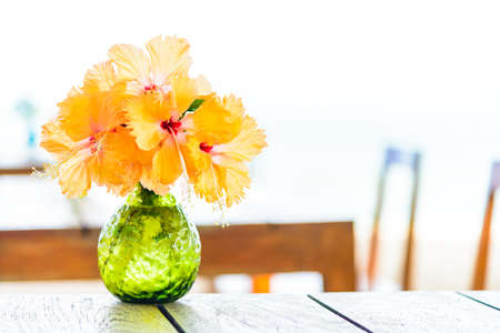 Vase flower on wooden table with sea backgroundの写真素材
