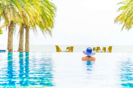 Woman wearing hat in the hotel pool resortの写真素材