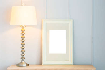 Blank frame with light lamp decoration on tableの写真素材