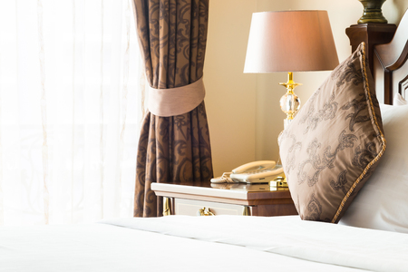 Pillow on bed with light lamp decoration in bedroom interiorの写真素材