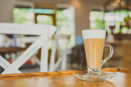 Hot latte coffee cup in coffee shop cafe - vintage filterの写真素材