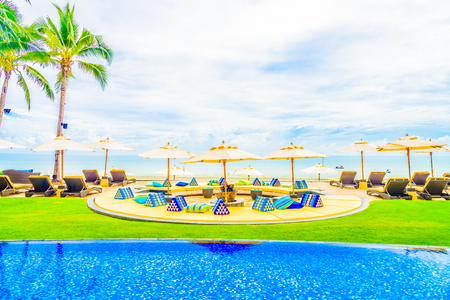 Beautiful Luxury Swimming pool with umbrella and chair in hotel resortの写真素材