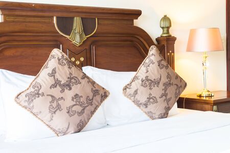 Pillow on bed with light lamp decoration in bedroom interiorの写真素材