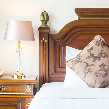 Pillow on bed with light lamp decoration in bedroom interiorの写真素材