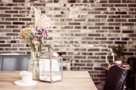 Dry flower in vase and candle decoration in coffee shop cafe - vintage filter effectの写真素材
