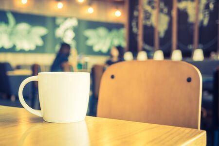 White coffee cup in coffee shop cafe - vintage filter