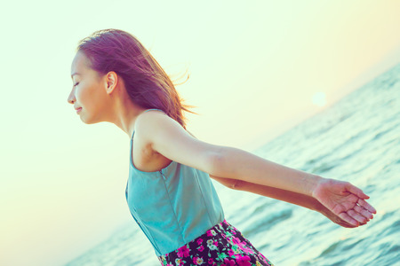 Happiness Young woman on the beach at sunset times - vintage effect and light leak filter processing style picturesの写真素材