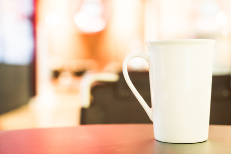 White coffee cup in coffee shop cafe - vintage filterの写真素材