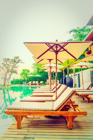 Umbrella and chair pool around beautiful luxury hotel swimming pool - Vintage Filterの写真素材