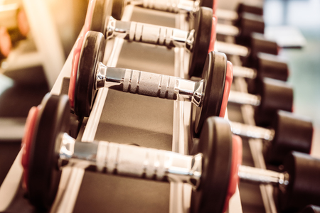 Selective focus point on Dumbbell equipment in fitness gym - Vintage filterの写真素材