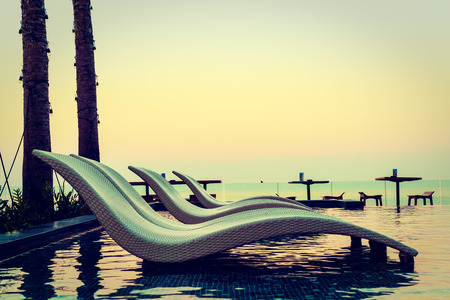 Umbrella and chair pool around beautiful luxury hotel swimming pool - Vintage Filterの写真素材