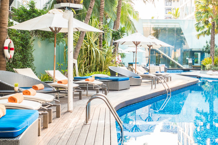 Umbrella and chair around beautiful luxury swimming pool in hotel resortのeditorial素材