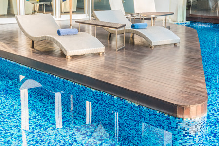 Umbrella and chair around beautiful luxury swimming pool in hotel resort