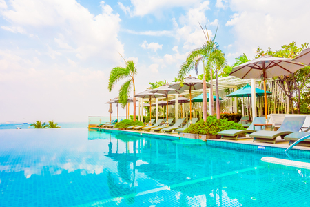Beautiful luxury swimming pool with umbrella and chair in luxury hotel resort - Boost up color Processing styleのeditorial素材