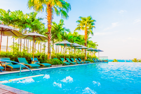 Beautiful luxury swimming pool with umbrella and chair in luxury hotel resort - Boost up color Processing styleのeditorial素材