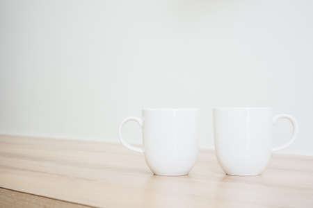 White coffee cup on table in livingroom interior - Light Vintage Filterの写真素材