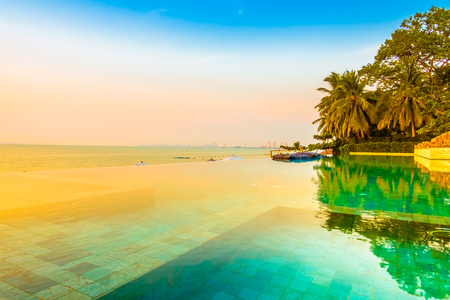 Beautiful luxury hotel swimming pool resort with umbrella and chair on the beach and sea - Vintage Filter and Boost up color Processingのeditorial素材