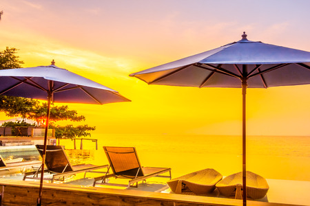 Beautiful luxury hotel swimming pool resort with umbrella and chair on the beach and sea - Vintage Filter and Boost up color Processingのeditorial素材
