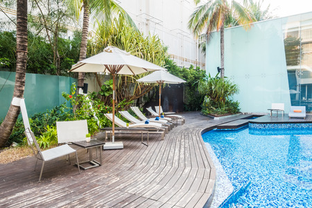 Umbrella and chair around beautiful luxury swimming pool in hotel resortのeditorial素材