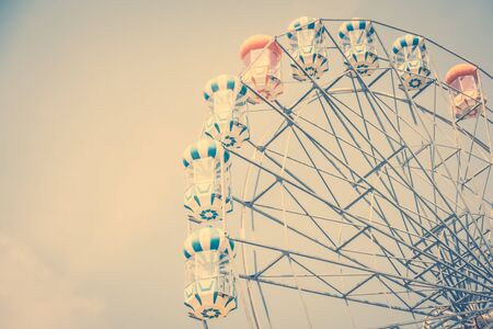 Vintage ferris wheel on blue sky background in the park - Vintage Filterの写真素材