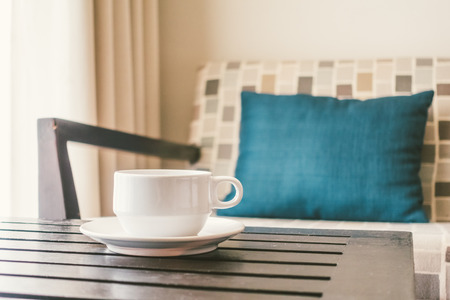 White coffee cup on table with sofa pillow decoration interior of living room - Vintage Light Filterの写真素材