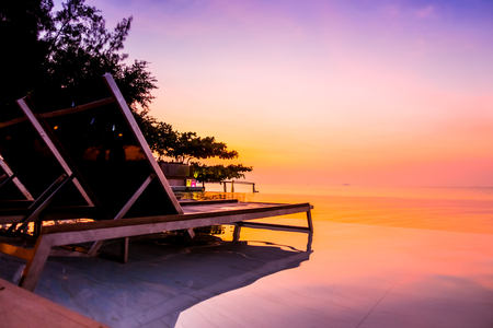Beautiful luxury hotel swimming pool resort with umbrella and chair on the beach and sea - Vintage Filter and Boost up color Processingのeditorial素材