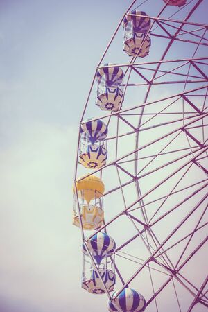 Vintage ferris wheel on blue sky background in the park - Vintage Filterの写真素材