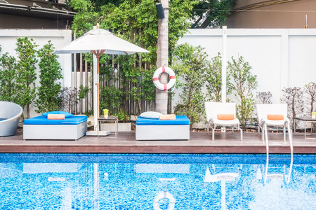 Umbrella and chair around beautiful luxury swimming pool in hotel resort
