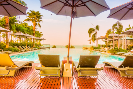 Beautiful luxury swimming pool with umbrella and chair in luxury hotel resort - Vintage Filter and Boost up color Processing styleのeditorial素材