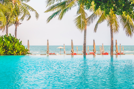 Beautiful luxury umbrella beach and chair around swimming in hotel resort - Boost up color Processingの写真素材