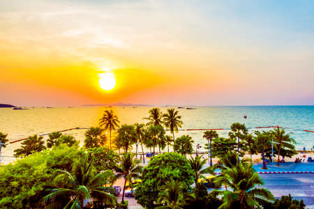 Silhouette palm trees on the beach with sunset - Vintage filter and boost up color processingの写真素材