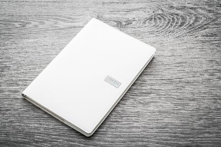 Blank white mock up book on wooden background - filter effect processingの写真素材