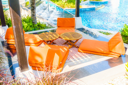 Empty Umbrella and chair around swimming pool in hotel resortの写真素材