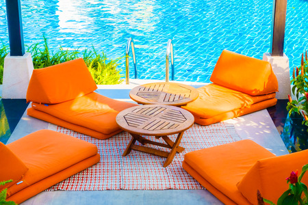 Empty Umbrella and chair around swimming pool in hotel resort