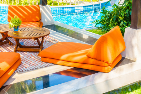 Empty Umbrella and chair around swimming pool in hotel resortの写真素材