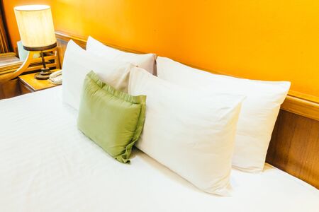 Beautiful luxury Pillow on bed with light lamp decoration in bedroom interior - Vintage Light Filterの写真素材