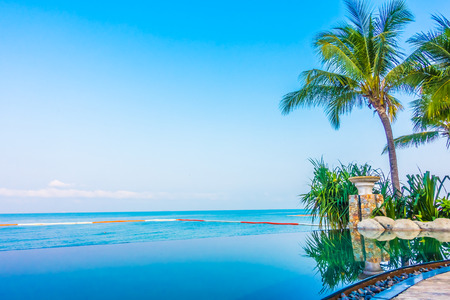 Luxury swimming pool landscape with palm tree and Sea & Ocean  background in hotel resort - Boost up color Processingの写真素材