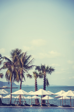 Umbrella and empty chair around swimming pool in hotel resort - Vintage Filterの写真素材